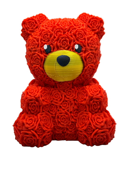 A handcrafted Forever Rose Bear made with red foam roses, shaped like a bear, with a yellow face and a red ribbon around its neck.